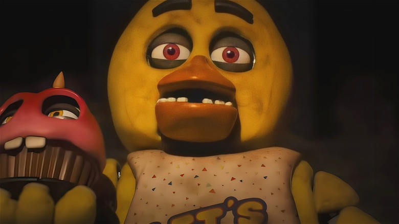 Chica the Chicken holding cupcake